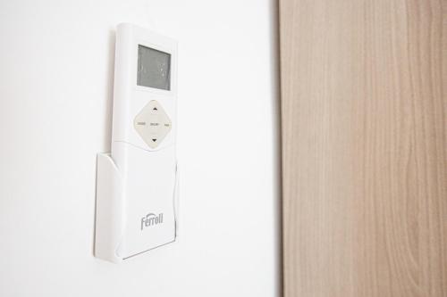 a white refrigerator with a control button on a door at Enjoy Apartment - Guest House in Ciampino
