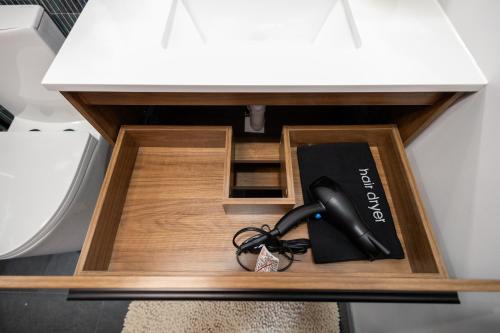 a black phone in a drawer under a desk at 3BR3Bth Penthouse 2 Parking Spaces TD MIT Harvard in Somerville