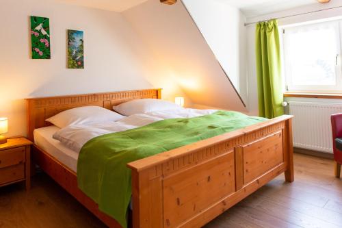 a bedroom with a wooden bed with a green blanket on it at Ferienwohnung Altstadtidylle 2 in Wernigerode