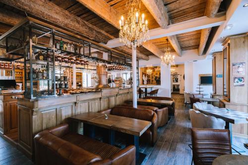 a restaurant with tables and chairs and a bar at Le Hameau Des Pesquiers Ecolodge & Spa, Curio Collection By Hilton in Hyères