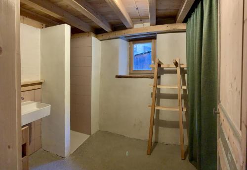 una habitación con una escalera al lado de una ventana en Appartement - Saint Véran, en Saint-Véran