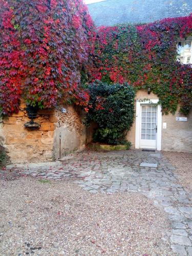 a building with red flowers on the side of it at Le Relais Cicero in La Flèche