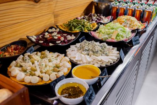 a buffet line with many different types of food at Ibis Budget Guarulhos Aeroporto in Guarulhos