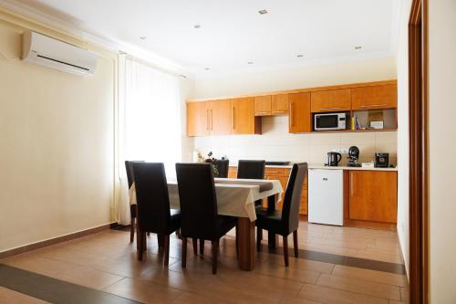 a kitchen with a dining room table and chairs at Lak6 Apartment in Mórahalom