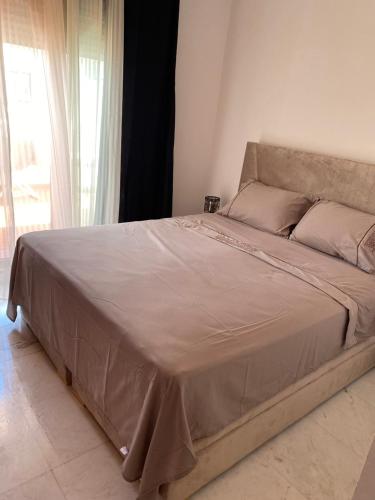 a large bed in a bedroom with a large window at Dar sam in Tangier