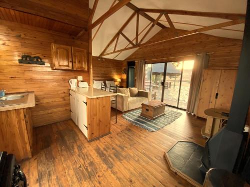 a kitchen and living room in a log cabin at Nullarbor Cottages in Magaliesburg