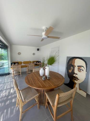 a dining room with a table with chairs and a painting of a face at Olvion Luxury Living in Kallithea Halkidikis