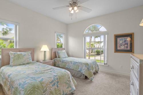 a bedroom with two beds and a ceiling fan at Halliday in Sanibel