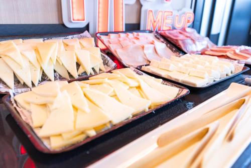 a bunch of cheese and meats on trays on a table at Ibis Malaga Centro Ciudad in Málaga
