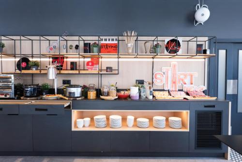 a kitchen with a counter with dishes on it at Ibis Malaga Centro Ciudad in Málaga