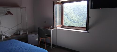 a bedroom with a window and a desk and a chair at Contrada Cafaro in Salerno