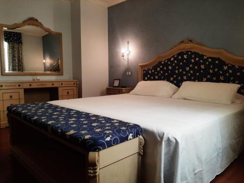 a bedroom with a large bed and a mirror at Hotel GBC Celta in A Guarda