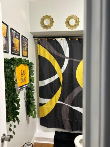 a bathroom with a black and yellow shower curtain at Sun-Kissed Stays in Galveston