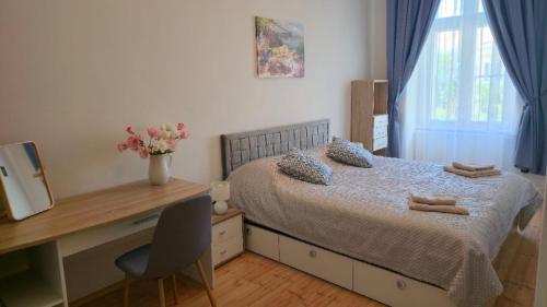 a bedroom with a bed with a desk and a window at Fountain Residence in Sopron