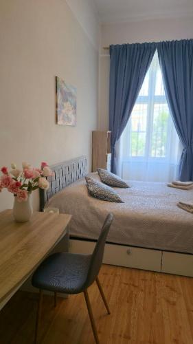 a bedroom with a bed and a chair and a window at Fountain Residence in Sopron