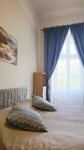 a bedroom with a bed with pillows and a window at Fountain Residence in Sopron