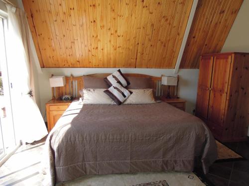 a bedroom with a bed with two pillows on it at Nullarbor Cottages in Magaliesburg