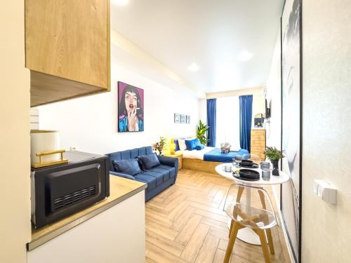 a living room with a blue couch and a table at Monroe Chic Studio in Tbilisi City