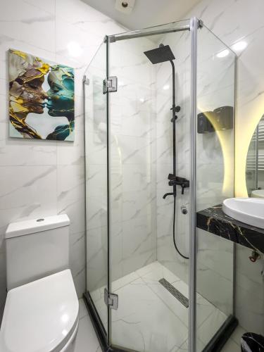 a bathroom with a shower and a toilet and a sink at Monroe Chic Studio in Tbilisi City
