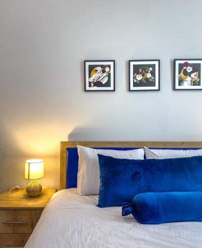a blue pillow sitting on a bed with four pictures on the wall at Monroe Chic Studio in Tbilisi City