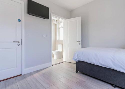 a bedroom with a bed and a flat screen tv at Twin Suite On Golf Course Private Cosy in Tramore