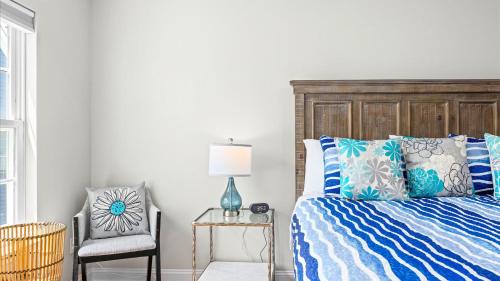 シーサイド・ハイツにあるNEW - Seaside Haven - 3BR - Steps to Boardwalkのベッドと椅子のある寝室