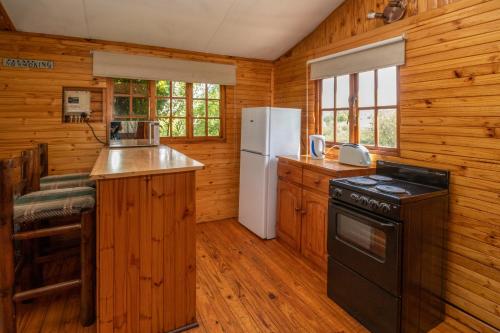 a kitchen with a stove and a refrigerator at Nullarbor Cottages in Magaliesburg