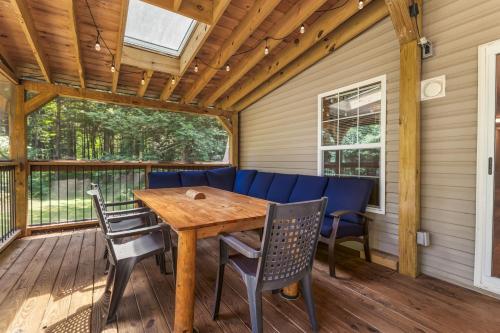 a porch with a wooden table and chairs at Schroon River Bend Getaway in Schroon Lake