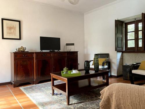 a living room with a tv and a coffee table at Quinta da Faísca Guesthouse in Vila do Conde