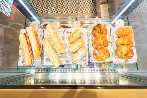 a display case with bread and croissants and pastries at Ibis Malaga Centro Ciudad in Málaga