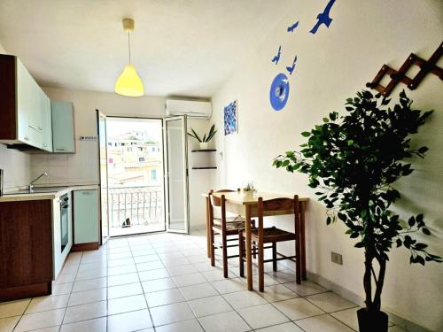 a kitchen with a table and a potted plant at Bentos - Appartamenti in centro a Orosei in Orosei