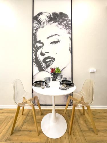 a table and two chairs in a room with a picture at Monroe Chic Studio in Tbilisi City