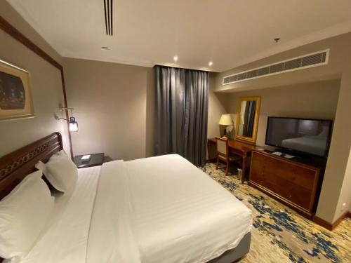 a hotel room with a bed and a flat screen tv at Elite Park Hotel in Jeddah