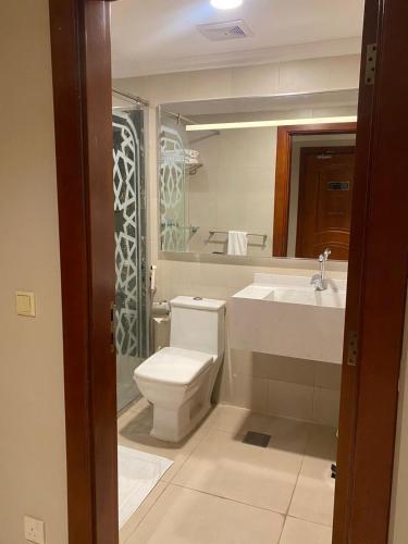 a bathroom with a toilet and a sink and a mirror at Elite Park Hotel in Jeddah