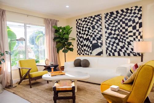 a living room with a white couch and chairs at colorfully designed 4 bedroom home with pool in Pompano Beach