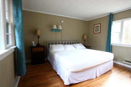 a bedroom with a large white bed and a window at The Pines Cottages in Asheville