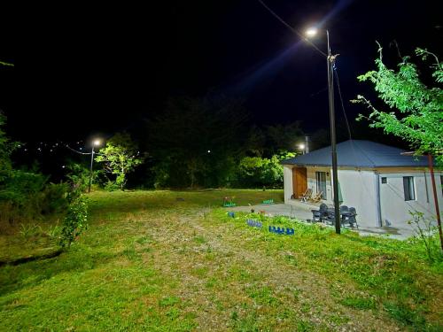 a house with a light on the side of a field at Guest house "Soulmate" in Ambrolauri
