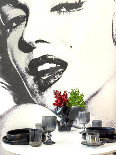 a table with plates and a painting of a woman at Monroe Chic Studio in Tbilisi City