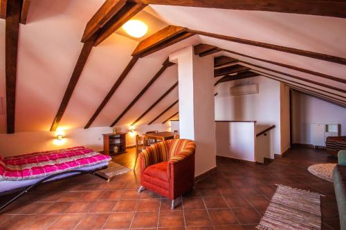 a attic room with a bed and a chair at Apartman Joso in Diklo