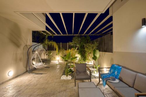 a patio with a couch and chairs and plants at Arieldine Luxury Apartment in Chania Town