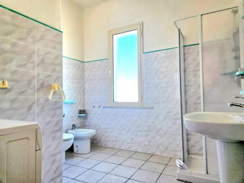 a bathroom with a toilet and a sink and a shower at Bentos - Appartamenti in centro a Orosei in Orosei