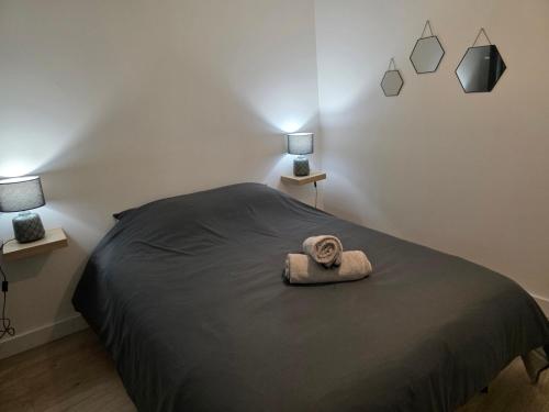 a bedroom with a bed with a towel on it at T2 Cosy Centre ville Clim & Wifi in Aubenas