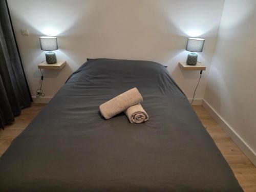 a bedroom with a bed with a towel on it at T2 Cosy Centre ville Clim & Wifi in Aubenas