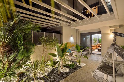 an indoor garden with palm trees and plants at Arieldine Luxury Apartment in Chania Town