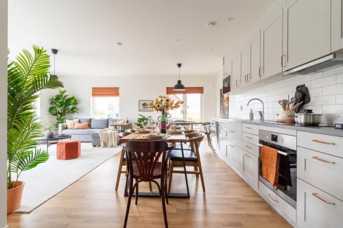 a kitchen and living room with a table and chairs at Modern Ground Floor Corner Flat with Rustic Patio in Båstad