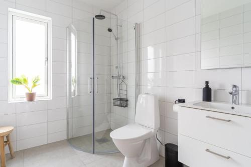 a bathroom with a toilet and a shower and a sink at Modern Ground Floor Corner Flat with Rustic Patio in Båstad