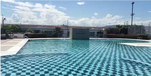 a swimming pool with a checkered tile floor at Casa vacacional Mangos Flandes - Girardot in Flandes