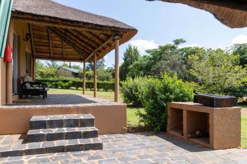 a pavilion with a grill on a patio at Nullarbor Cottages in Magaliesburg