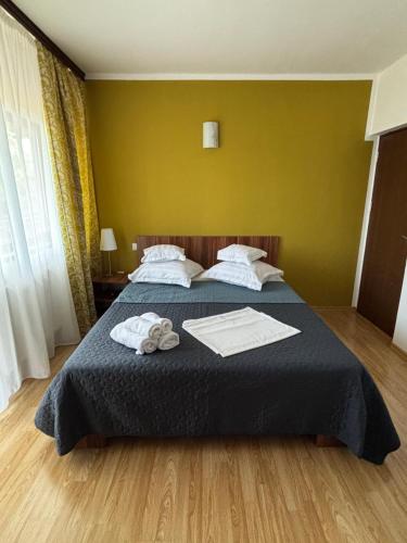a bedroom with a bed with two towels on it at Helen Rooms Vama Veche in Vama Veche