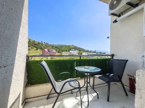 a patio with two chairs and a table on a balcony at Monroe Chic Studio in Tbilisi City